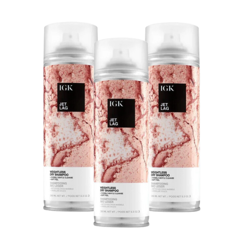 Three IGK Jet Lag Dry Shampoo bottles with marbled pink designs.