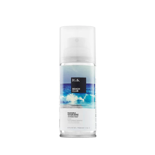 A bottle of IGK Beach Club texture spray with ocean imagery on the label.