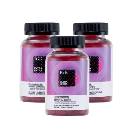 Three bottles of IGK Extra Extra biotin gummies for hair displayed together.