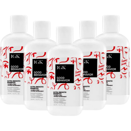 Five bottles of IGK Good Behavior Ultra Smooth Shampoo with decorative labels.