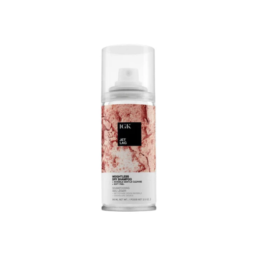 A can of IGK Jet Lag Invisible Dry Shampoo with a pink marble design.