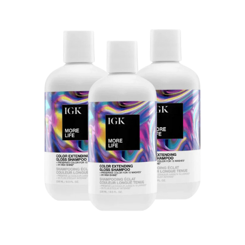 Three bottles of IGK More Life color-extending gloss shampoo with colorful labels.